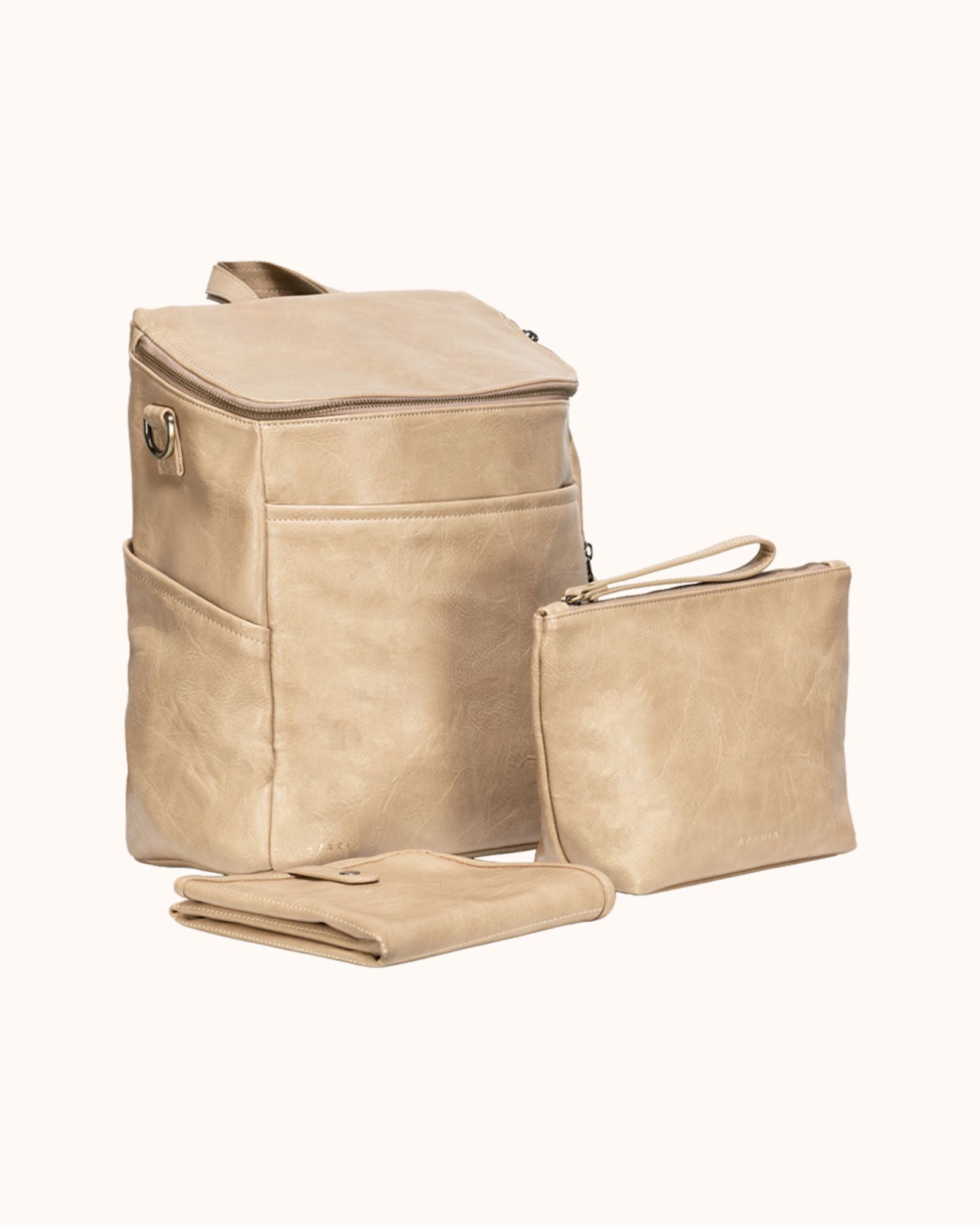 Beige leather backpack, pouch, and blanket set on a white background