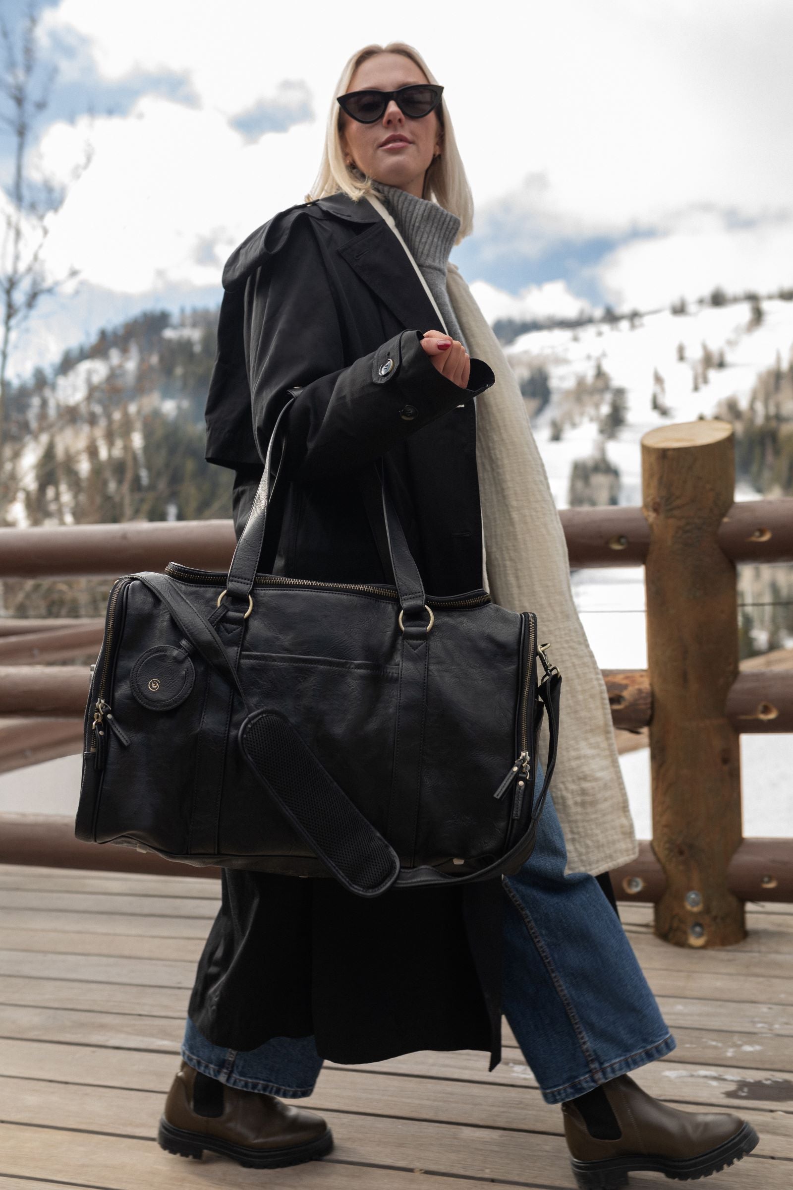 Model walking with black AZARIA madeleine weekender bag