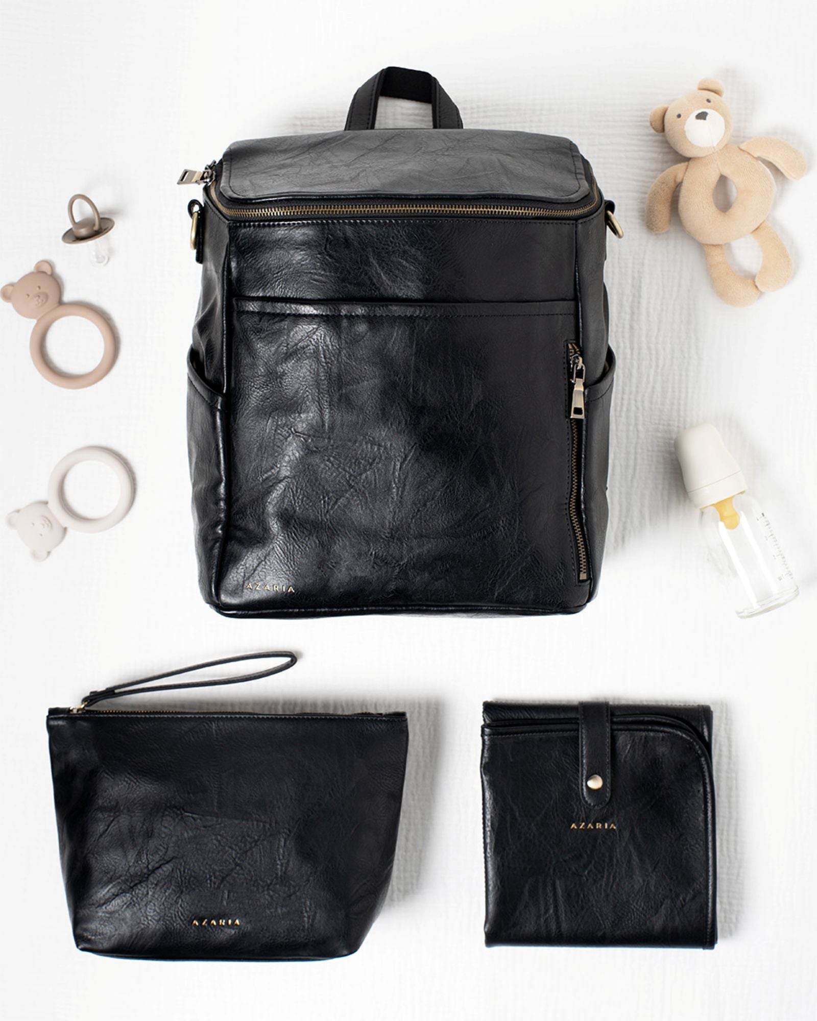 Black vegan leather diaper bag set with accessories on a white background