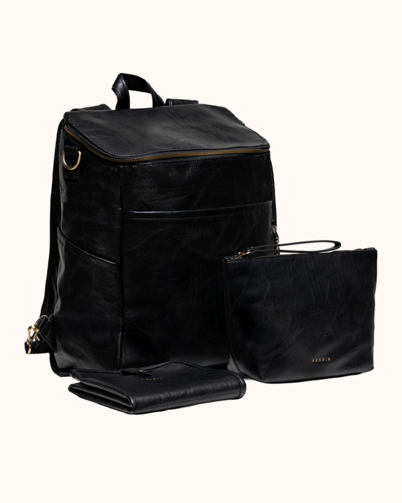 Black leather backpack, pouch, and folded mat on a white background