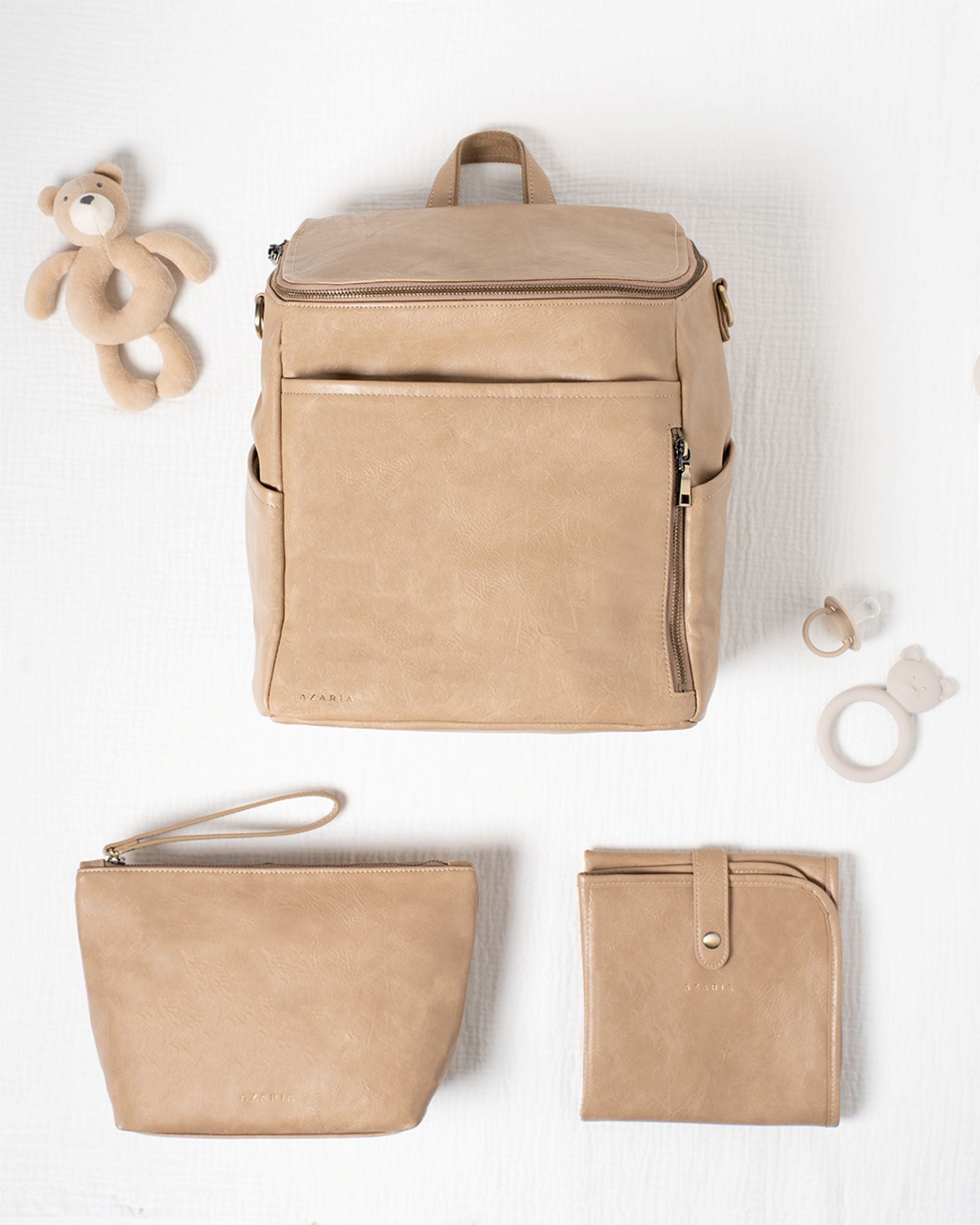 Beige vegan backpack and pouches on a white background with baby items.